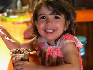 Young girl smiling while eating chocolate icecream at The Lodge at Cedar Rapids Lodge in Tenstrike, MN